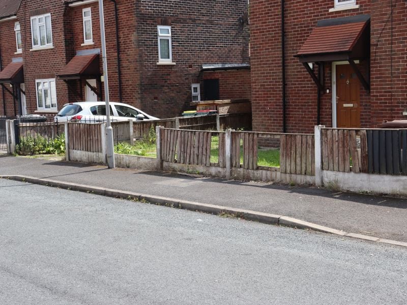 A broken fence with a full section missing and other panels