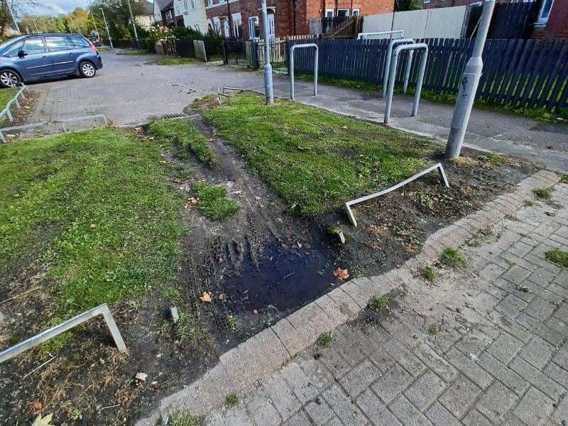 A patch of grass with damage caused by motorbikes driving over it