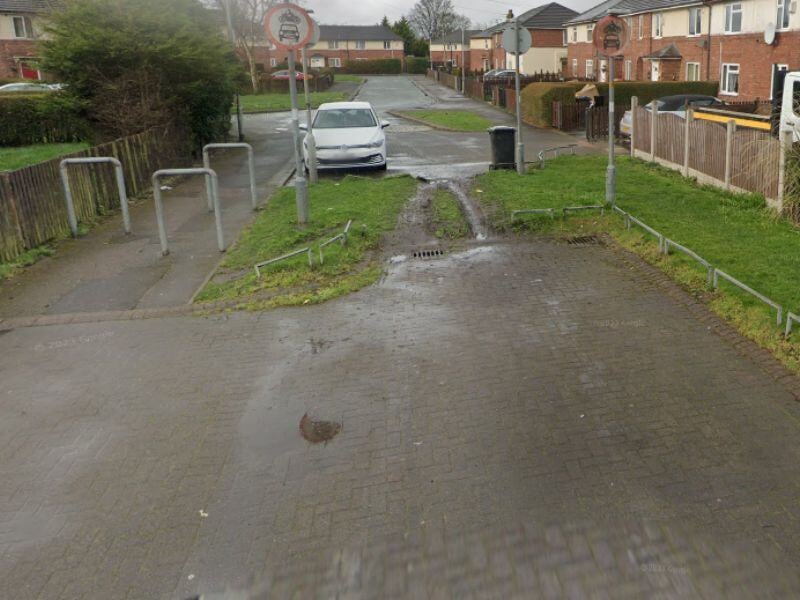 Wide angle view of a patch of grass with damage caused by motorcycles riding over it