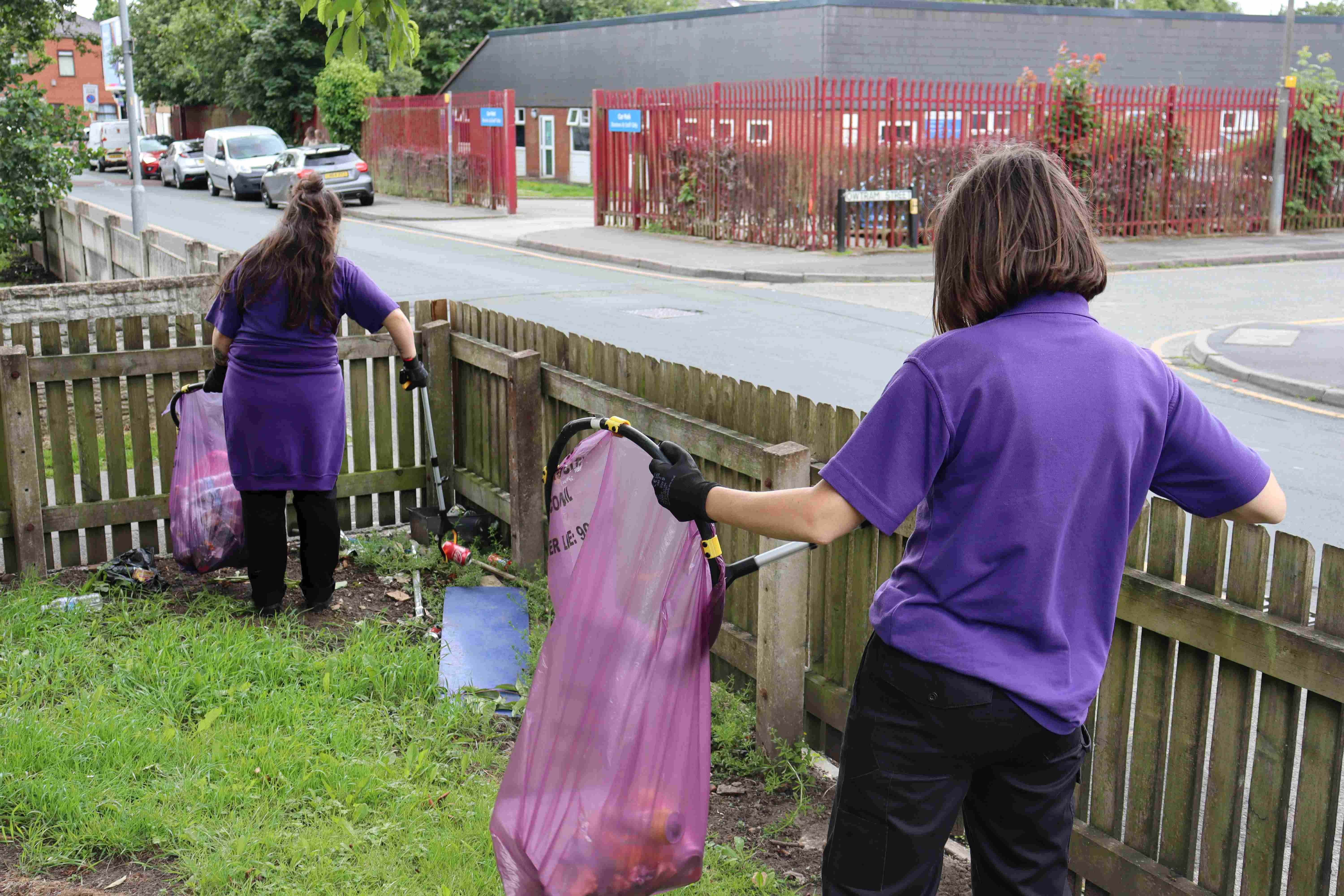 Two female members of CGA staff picking litter