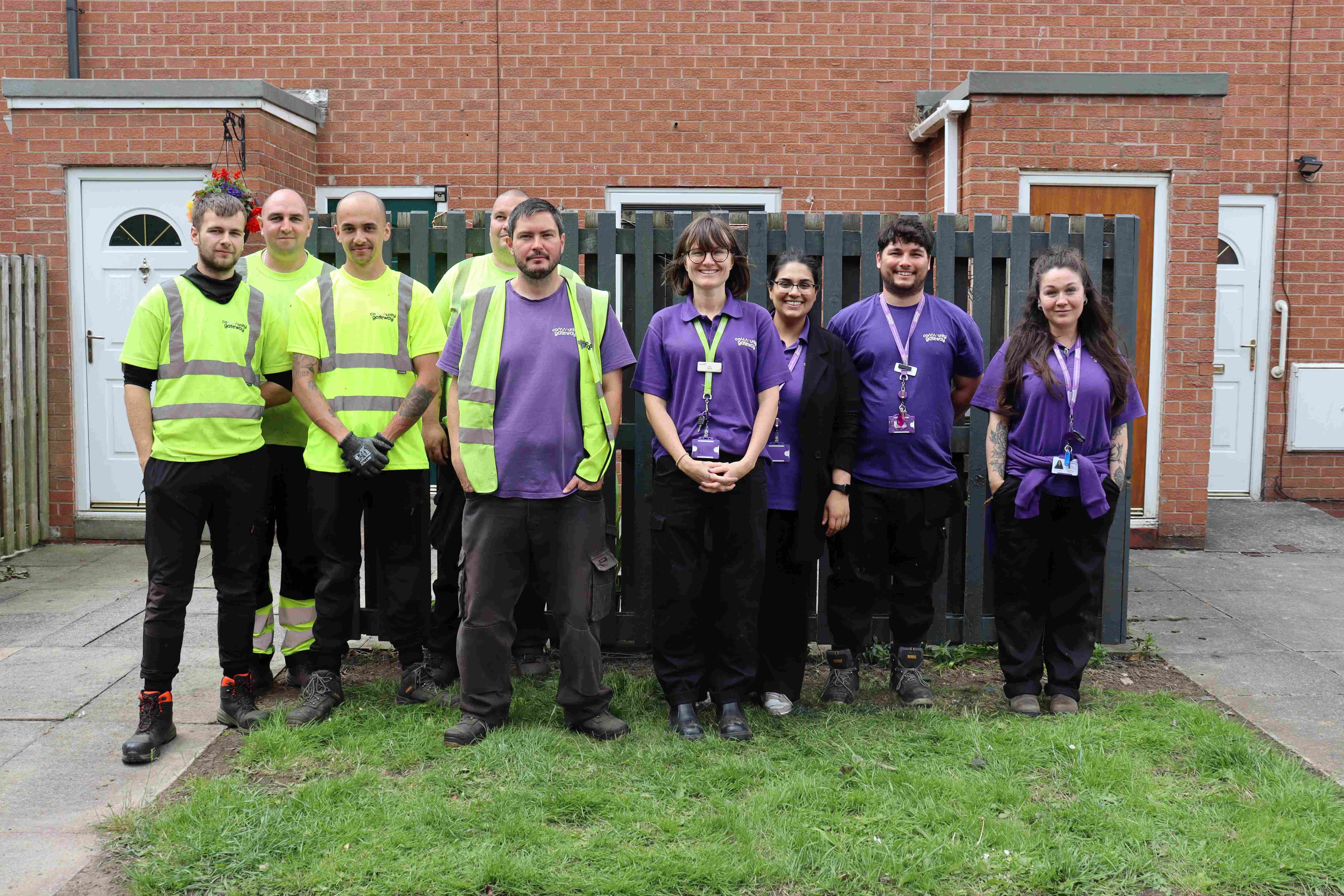 A team photo of CGA staff, some with high vis and some with purple tops
