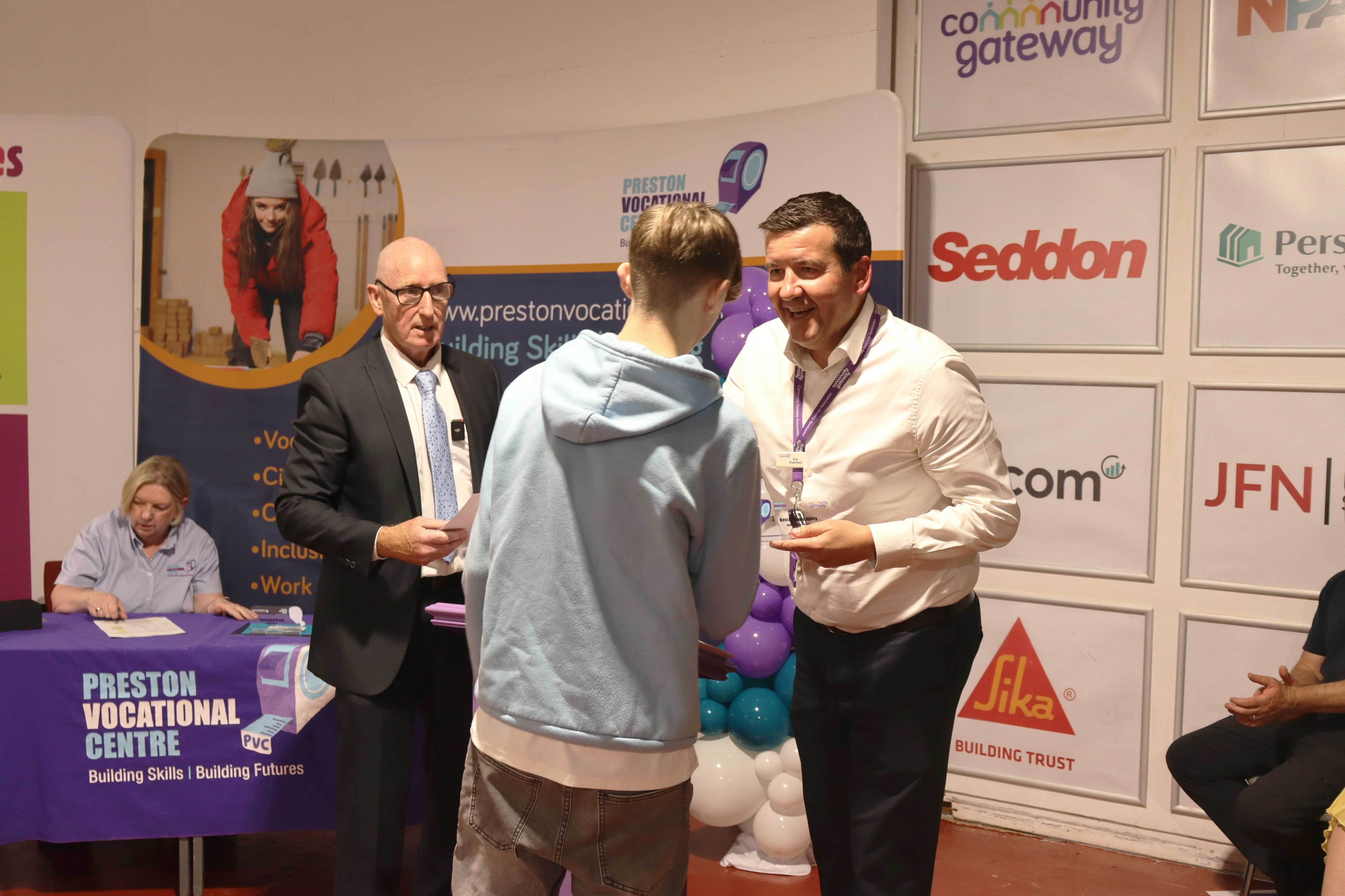 CGA Chief Executive shaking hands with and handing an award to a PVC award winner