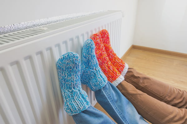 This is an image of two pairs of feet on the radiator 